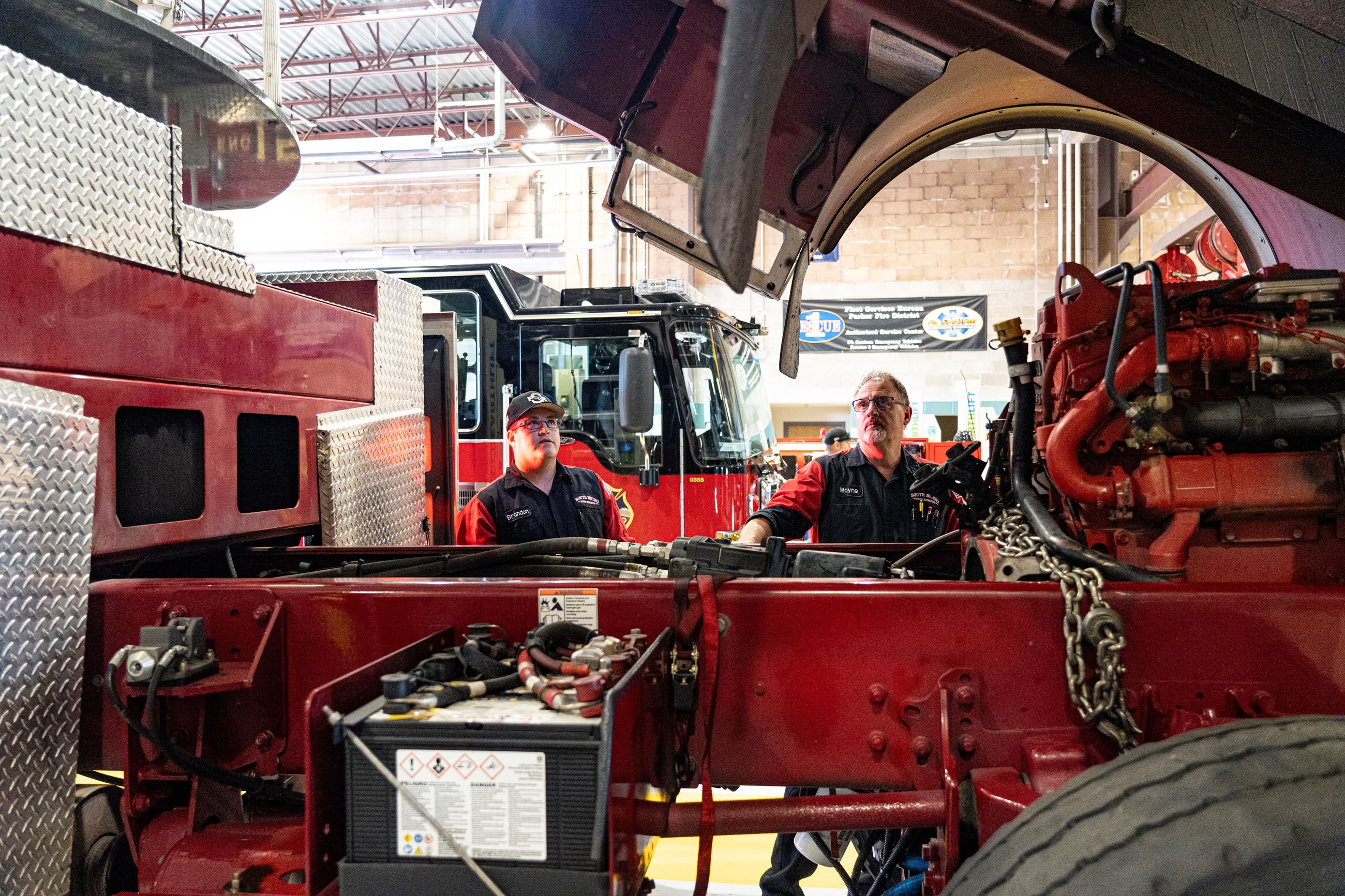 Fleet Workers Inspecting Under the Hood of a Vehicle